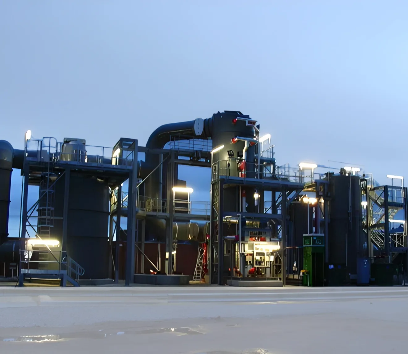 Large industrial air treatment and filtration plant with multiple tanks, ducting and access platforms at an outdoor site
